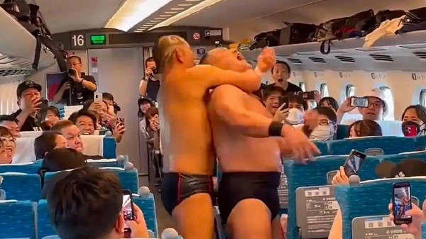 Two WWE wrestlers battle between a moving bullet train in Japan